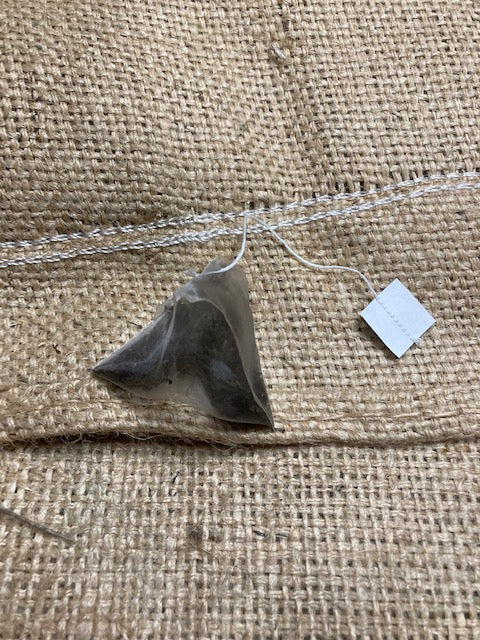 Single #HEXHero pyramid teabag on hessian background